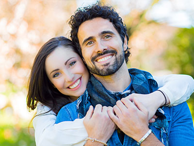 A man and a woman are embracing in a warm, happy pose.